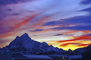 Colourful sunset behind snow-covered mountains