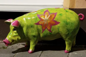 Colourfully painted pig serving as an object of art in front of a store