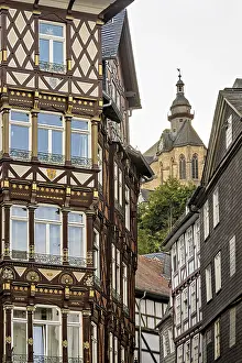 Framed Print : Combination of elaborate half-timbered details and Gothic church tower in the cityscape Framed Print : Combination of elaborate half-timbered details and Gothic church tower in the cityscape