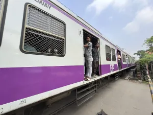 Commuter train with open doors and standing passengers on a railway line