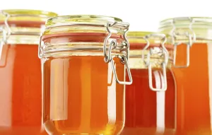 Composition with jars of honey isolated on white background