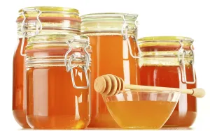 Composition with jars of honey isolated on white background