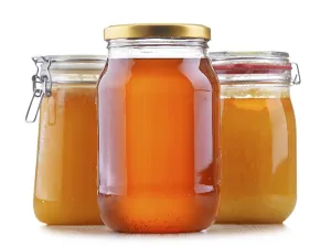 Composition with large jars of honey isolated on white