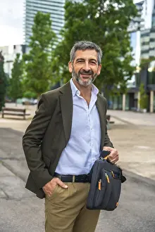 Confident mature businessman with beard and suit jacket smiling at camera