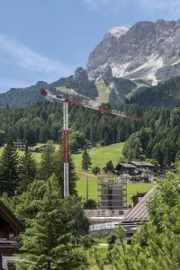 Construction crane in front of a mountain backdrop in Cortina