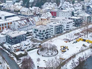 Construction site next to modern residential buildings in a snowy cityscape
