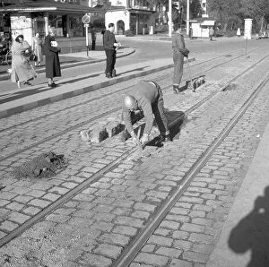 Construction workers paving a road around 1950