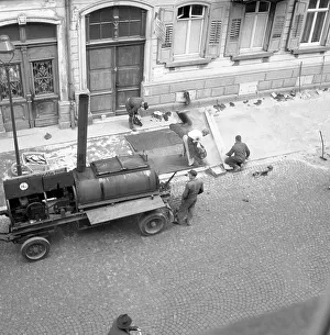 Construction workers repair and tar the pavement