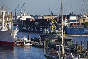 Container ship of the shipping company CMA CGM with many different ships in the port of Hamburg