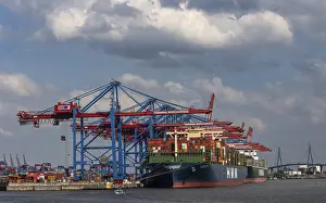 Container ships are unloaded by large cranes in the harbour