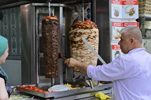 A cook prepares doner kebab at a street food stall