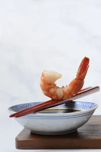 Cooked shrimp on chopsticks and shell with soy sauce