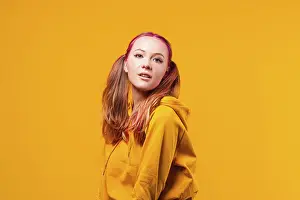 Cool young woman posing in yellow hoodie