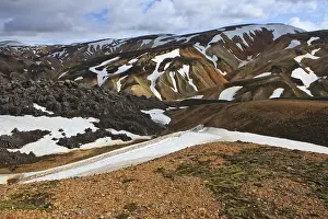 Cooled lava field with snow fields in a volcanic landscape