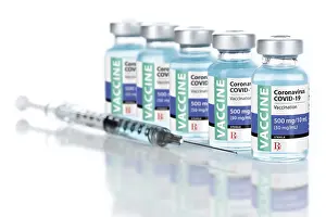 Coronavirus COVID-19 vaccine vials and syringe on reflective surface