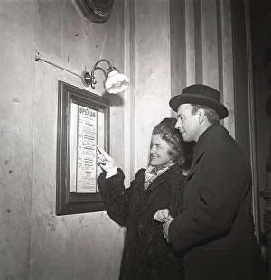 Couple in 1948. They stand at an information board