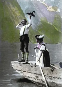 Couple in Bavarian traditional costume in a rowboat on lake Koenigssee
