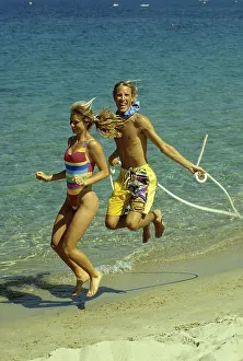 Couple on the beach, beach running and jumping rope