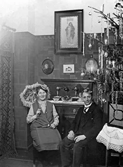 Couple celebrates Christmas in the living room next to the Christmas tree