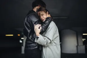 A couple in a comforting embrace in a subdued setting