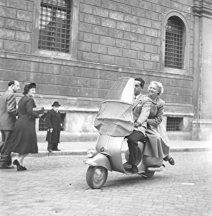 Couple in Italy in the 1950s. A young couple on a Vespa scooter driving on a street in Milan Italy 1950. Photo Kristoffersson Ref AY28-7