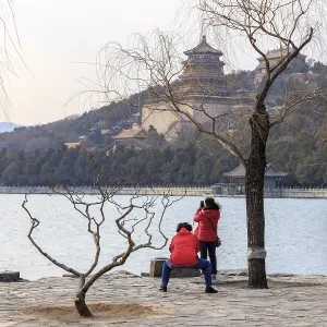 Couple in red jackets take photos at the Summer Palace in Beijing