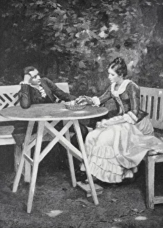 A couple sitting at a table in the garden having a conversation