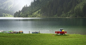Category Mountain Landscapes Prints: Couple with umbrella sitting in the rain at Vilsalpsee in Tyrol