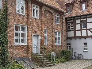 A courtyard with old brick and half-timbered houses