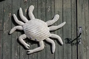 Crab woven from rope, hanging from a green wooden door