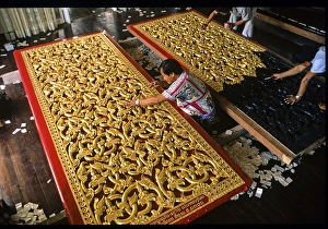 Craftsmen gilding doors with gold leaf