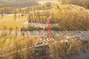Crane dominates construction site in autumn landscape