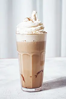 Creamy iced coffee, topped with whipped cream and cinnamon
