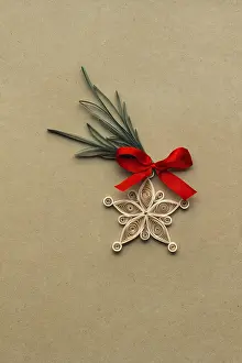 Creative Christmas concept photo of a snowflake made of qulling paper on brown background