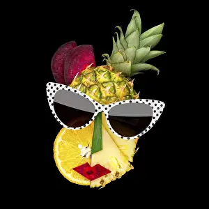 Creative concept photo of a female face in cubist style with sunglasses made of fruit and vegetables