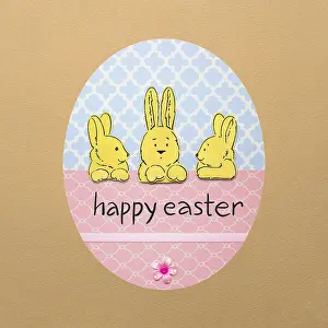 Creative Easter concept photo of three rabbits in a colourful paper egg on a brown background