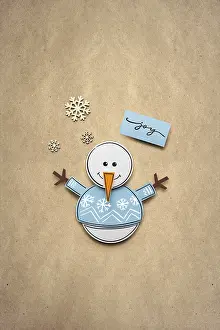 Creative photo of a paper snowman on a brown background