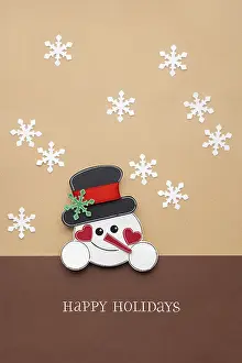 Creative photo of a paper snowman on a brown background
