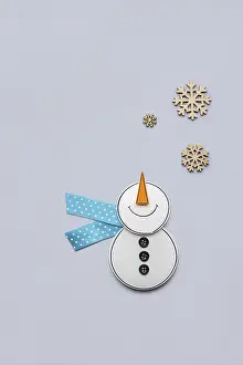 Creative photo of a paper snowman on a grey background