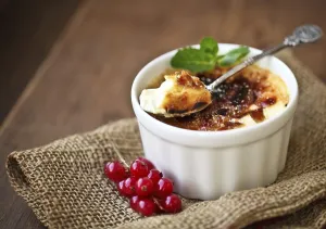Creme brulee (cream brulee, burnt cream) with red currant and mint