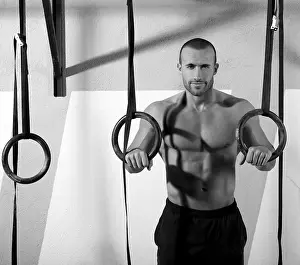 Crossfit dip ring man relaxed after workout at gym dipping exercise