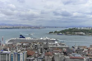 Cruise ship at the harbour with city view and cloudy horizon