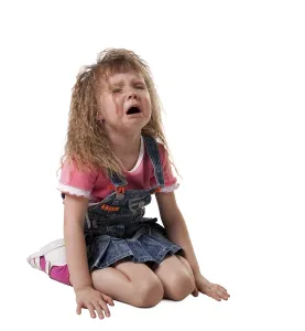 Crying kid sit on white, jeans cloth - isolated
