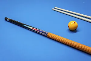Cue sticks and a yellow ball on a billiard table