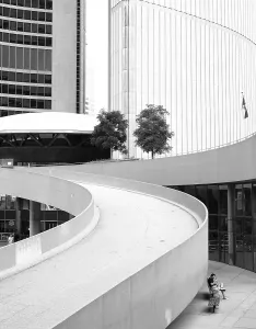 A curved ramp between modern buildings in a black and white setting in Toronto
