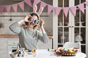 Cute adult woman playing with easter eggs