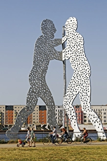 Cyclist in front of the Jonathan Borofsky's Molecule Man sculpture in the Spree River