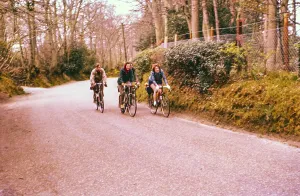 Four cyclists, two women, cycling on a country road, South of England, Great Britain 1957