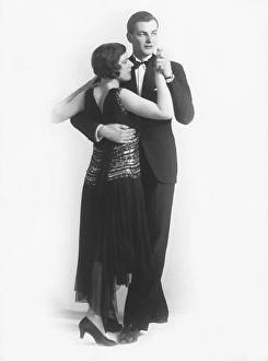Dancing in the 1930s. A young well dressed couple pictured in full figure posing as if they wer in the middle of a dance. A perfect example to illustrate elegant dancing