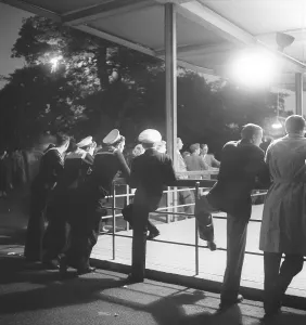 Dancing in the 1940s. A group of sailors are at a dance event and stands against the handlebar to the dancefloor looking. Photo Kristoffersson Ref AZ44-3. Sweden 1949